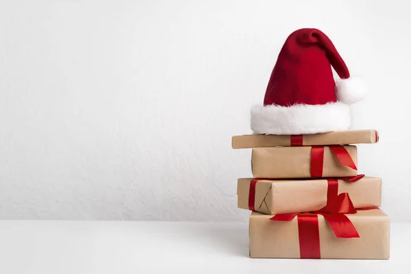 Regalos de Navidad decorados con cintas rojas puestas en el sombrero de Santas — Foto de Stock