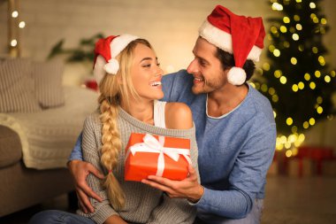 Noel konsepti. Mutlu adam kız arkadaşına hediye kutusu veriyor.