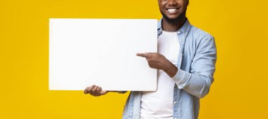 Siyah adam beyaz reklam panosu tutuyor ve onu işaret ediyor.