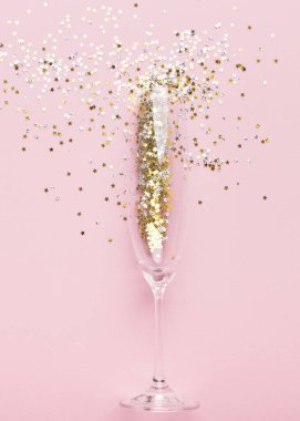Pembe üzerinde altın rengi süslemeli şampanya bardağı.