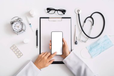 Çevrimiçi Danışmanlık. İş yerinde elinde boş ekranlı akıllı telefon tutan doktor.