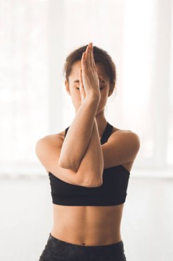 Kollarını kavuşturup yoga yapan bir kadın.