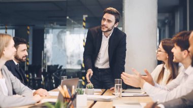 CEO, yönetim kurulunda iş arkadaşlarıyla konuşuyor.
