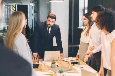 Erkek müdür ofiste meslektaşlarına sesleniyor