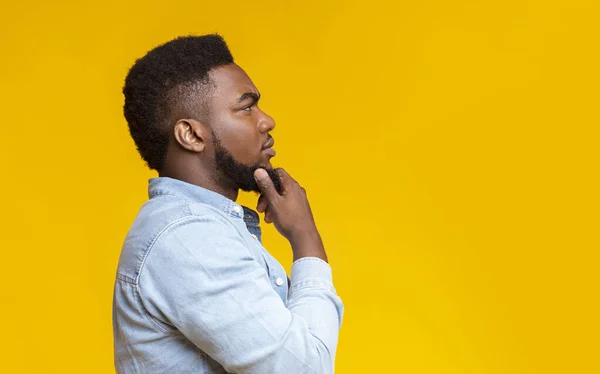 Profile portrait of thoughtful african american guy over yellow background — Stock Photo, Image