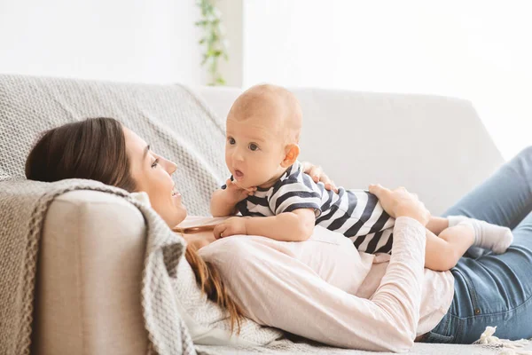 Funny poco bebé vinculación con mamá, acostado en el sofá juntos —  Fotos de Stock