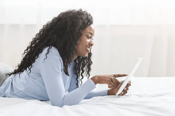 Hermosa afro chica sirviendo internet en la tableta digital — Foto de Stock