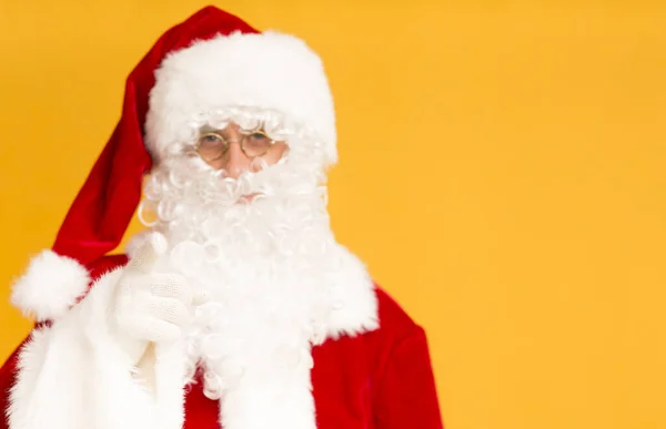 Santa Claus mostrando con el dedo en la cámara sobre naranja — Foto de Stock