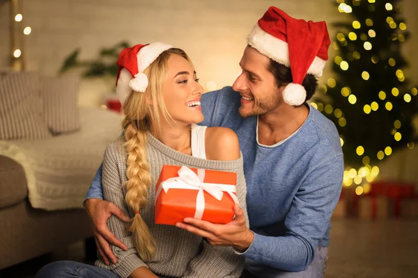 Weihnachtskonzept. glücklicher Kerl gibt Geschenkbox zu Freundin — Stockfoto