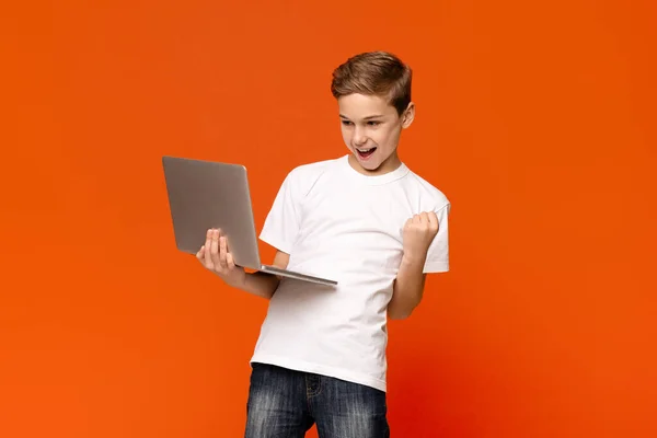 Podekscytowany nastolatek za pomocą laptopa, świętowanie sukcesu — Zdjęcie stockowe