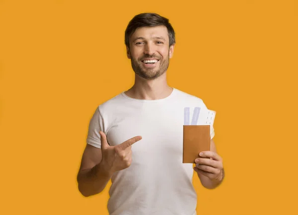 Hombre mostrando entradas y pasaportes señalando dedo de pie, Studio Shot — Foto de Stock