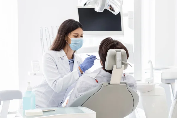 Dentista fazendo check-up para o paciente na clínica odontológica — Fotografia de Stock