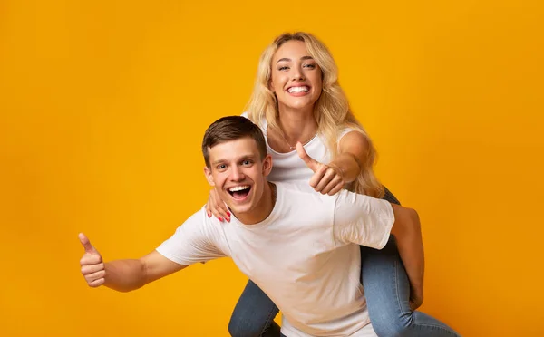 Joyful jovem casal se divertindo juntos e mostrando polegares para cima — Fotografia de Stock