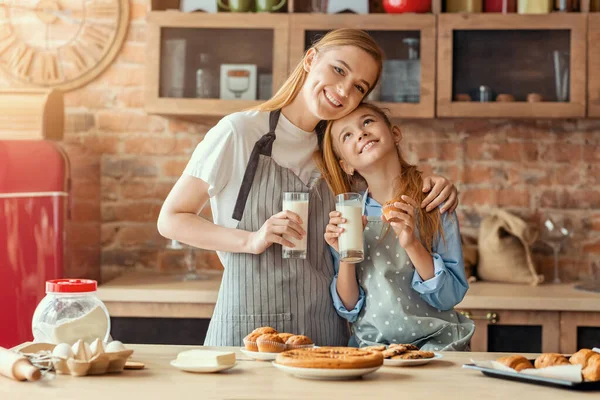 Feliz relación madre e hija mientras beben leche después de cocinar —  Fotos de Stock