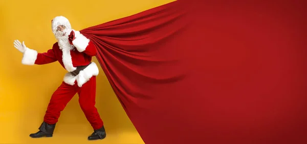 Weihnachtsmann und riesiger Sack mit Kopierplatz für Text auf Orange — Stockfoto
