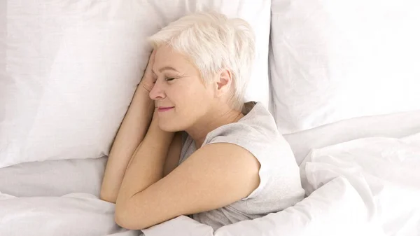Wanita senior yang sehat tidur siang di tempat tidur, pandangan atas — Stok Foto