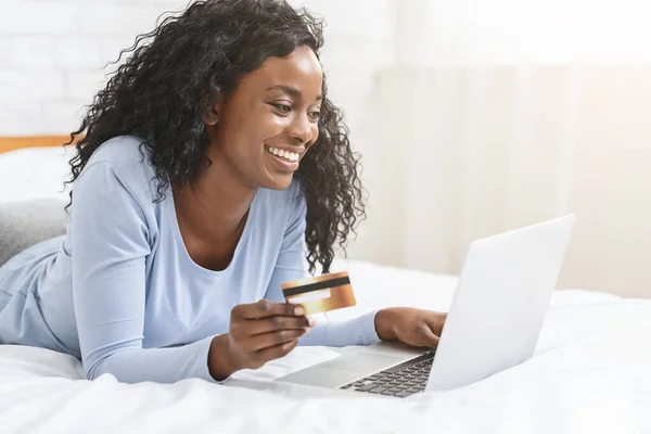 Счастливая чернокожая женщина совершает онлайн-покупки из дома — стоковое фото