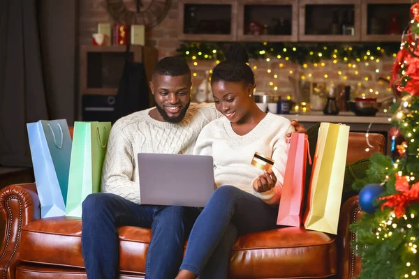 Afro casal compra presentes on-line, usando laptop e cartão de crédito — Fotografia de Stock