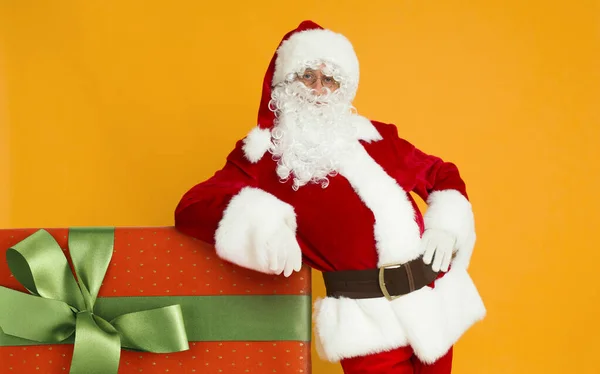 Weihnachtsmann posiert mit Weihnachtsgeschenk in großer roter Schachtel — Stockfoto