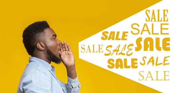Симпатичный афроамериканец кричит о продаже на жёлтом фоне — стоковое фото