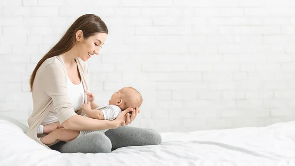 Mother playing with her little baby in bedroom — Stock Photo, Image