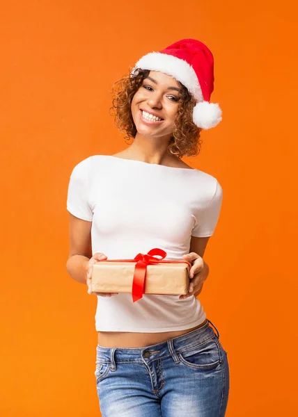 산타 모자를 쓰고 선물을 들고 있는 아름다운 흑인 소녀 — 스톡 사진