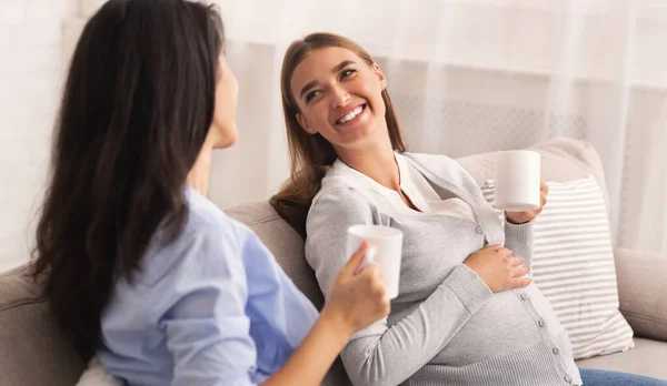 Schwangere unterhält sich mit Freundin beim Tee zu Hause — Stockfoto