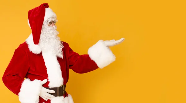 Papai Noel segurando espaço cópia na palma da mão sobre laranja — Fotografia de Stock