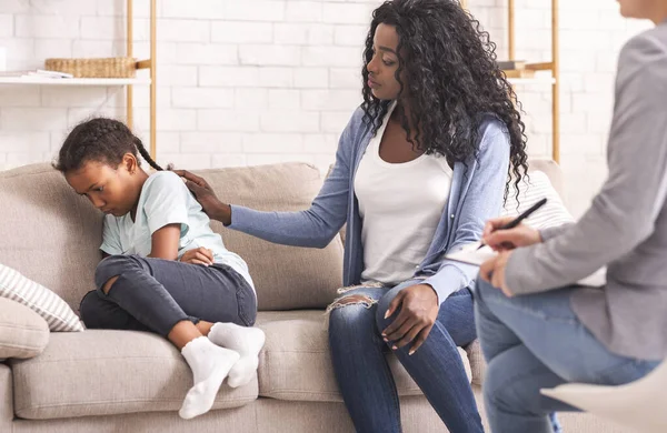 Matka uspokaja swoją zdenerwowaną nieposłuszną córeczkę podczas konsultacji psychologa — Zdjęcie stockowe