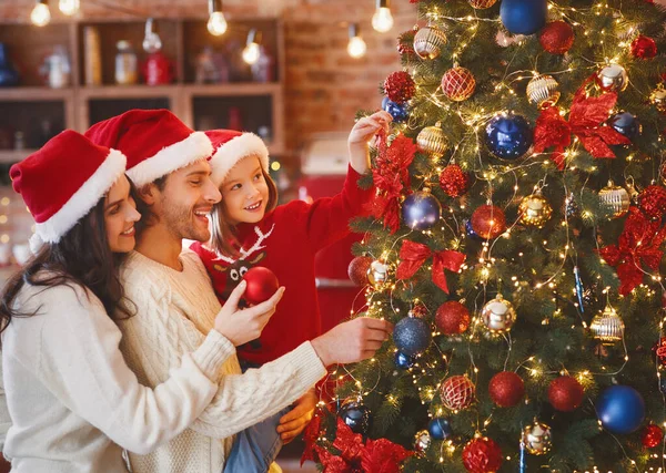 Lovely family decorating xmas tree with bubbles at home