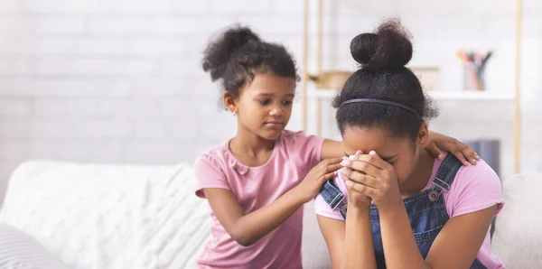 Little african american girl comforting her crying elder sister — Stock Image Little african american girl comforting her crying elder sister Stock Image