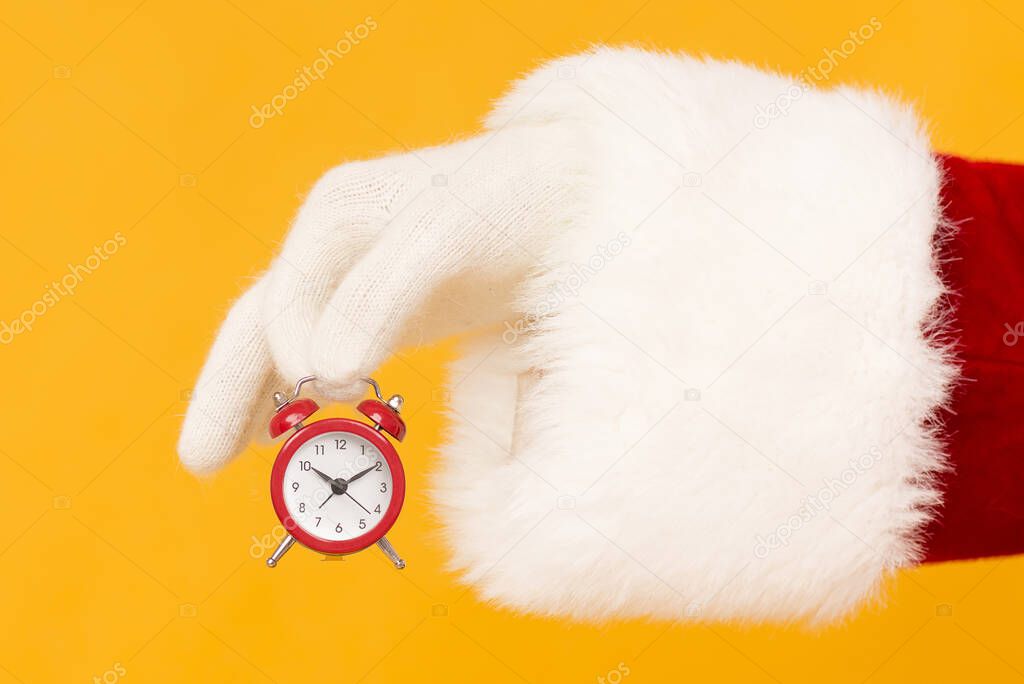 Santa holding retro red alarm clock on orange