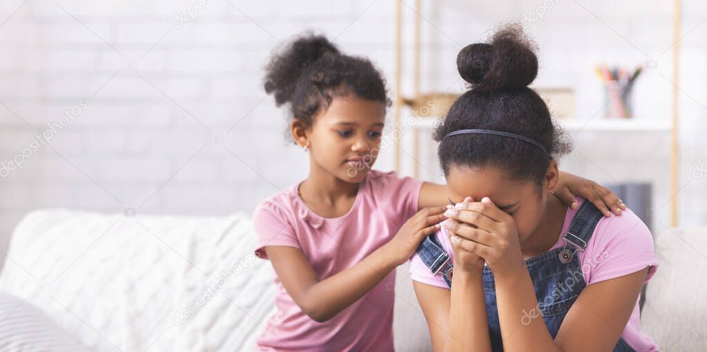 Little african american girl comforting her crying elder sister