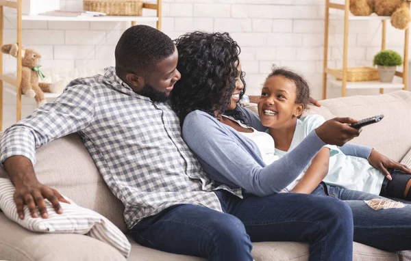 Χαρούμενη μαύρη οικογένεια τριών ατόμων που χαλαρώνουν στον καναπέ στο σπίτι — Φωτογραφία Αρχείου