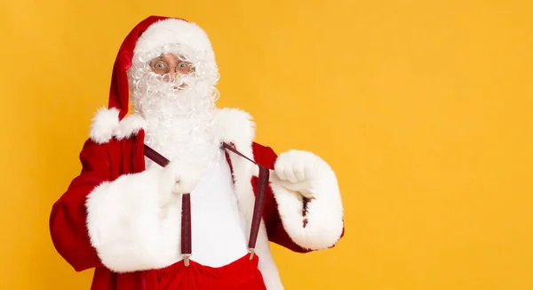 Funny Santa mostrando sus tirantes de Navidad sobre naranja — Foto de Stock