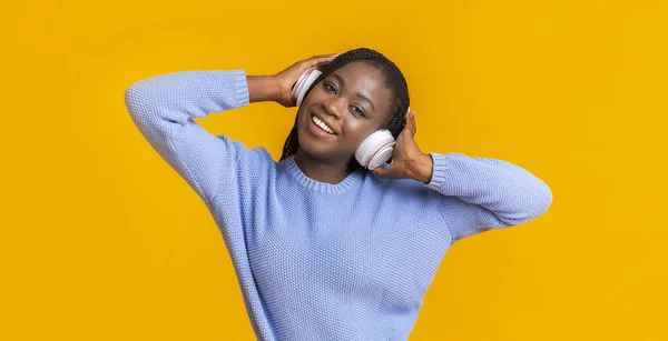 Carefree afro woman listening to music with wireless headset — Stock Photo, Image