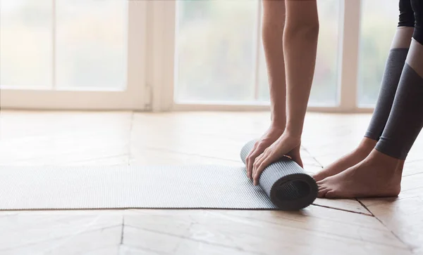 Abgeschnittenes Bild einer rollenden Sportmatte im Studio — Stockfoto