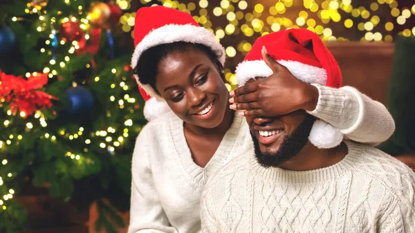 Femme aimante fermant les yeux des maris avec la main, préparé surprise de Noël — Photo