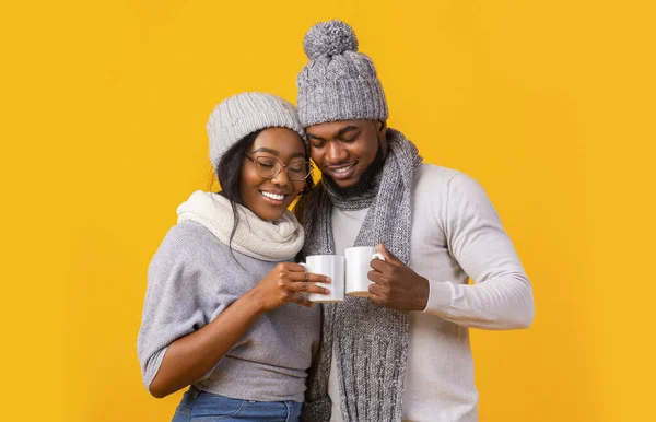 Novio de invierno y novia bebiendo café sobre fondo amarillo —  Fotos de Stock