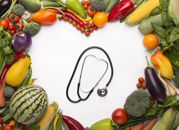 Stethoscope in the middle of heart frame of fresh vegetables