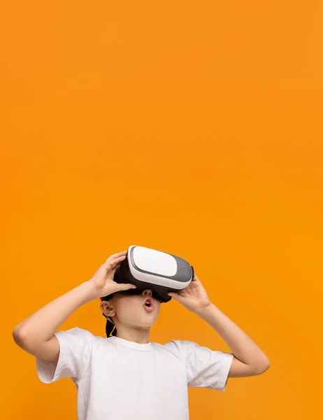Adolescente emocional disfrutando de la realidad virtual sobre fondo naranja —  Fotos de Stock