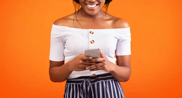 Afro Woman Using Smartphone Standing Over Orange Background, Cropped, Panorama — Stock Photo, Image