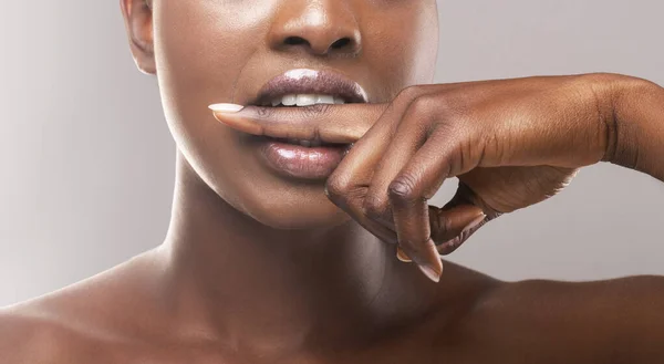 Menina americana africana irreconhecível mordendo o dedo para não compartilhar segredo — Fotografia de Stock