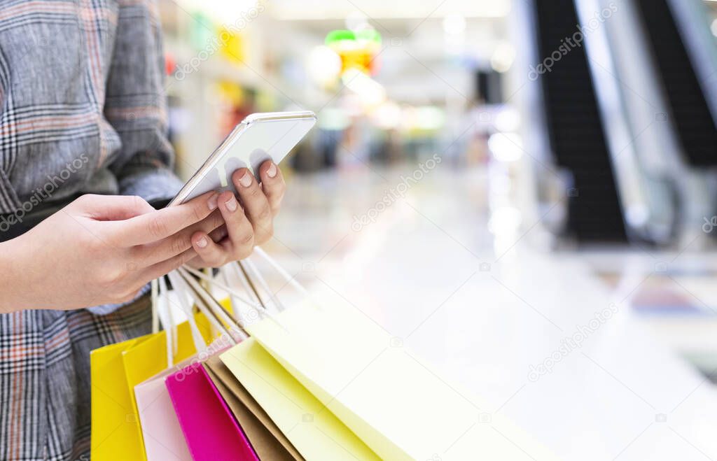 Woman using smartphone, making order online in mall