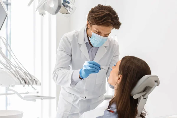 Dentista haciendo chequeo regular para su paciente — Foto de Stock