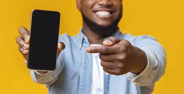 Man memegang smartphone dengan layar hitam dan menunjuk di atasnya — Stok Foto
