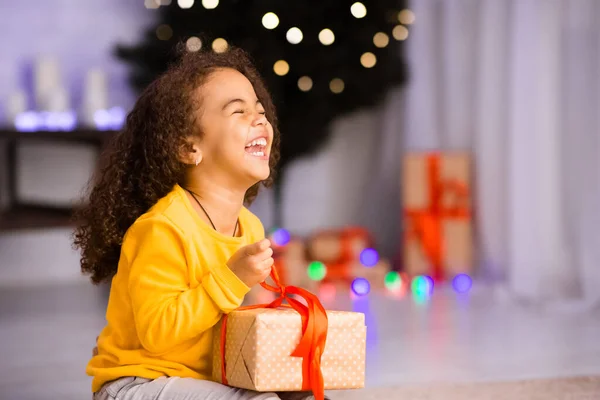 Garota africana excitada rindo com presente de Natal — Fotografia de Stock