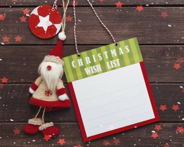 Oyuncak Noel Baba 'nın tahta arka planda olduğu Noel dileği listesi.