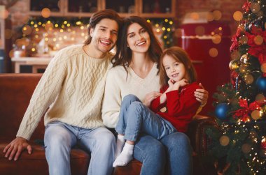 Dost canlısı aile Noel için hazırlanıyor, kanepede oturuyor.