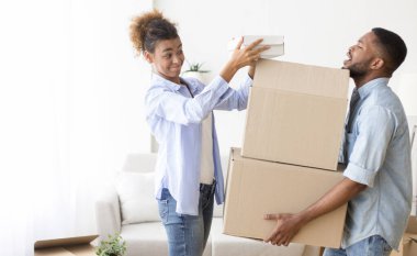 Yorgun koca eşiyle birlikte taşınma kutuları paketliyor.